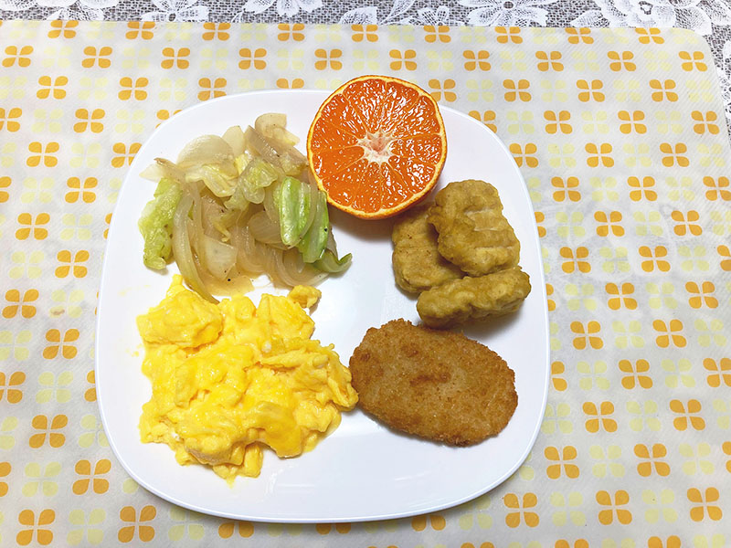 スクランブルエッグ、グラタンコロッケ、チキンナゲット、キャベツ路玉ねぎの炒め、オレンジ